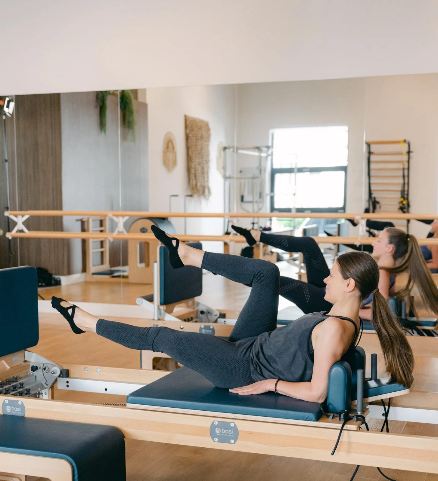 Două cliente lucrând pe reformer în sală